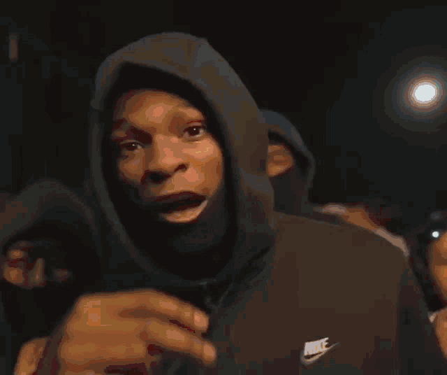 a man in a hoodie holds up a sign that says by a bitch rtp