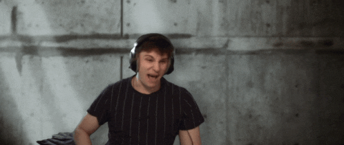 a man wearing headphones and a black striped shirt is making a funny face