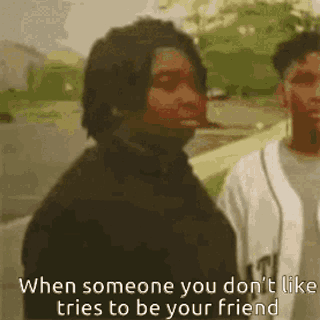 two men are standing next to each other with the caption when someone you don 't like tries to be your friend .