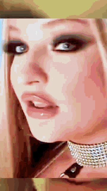 a close up of a woman 's face wearing a choker and earrings