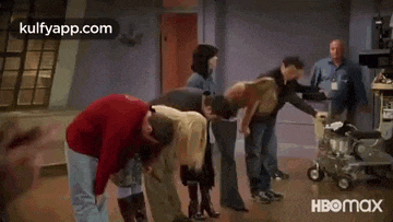a group of people are standing next to each other and holding hands .