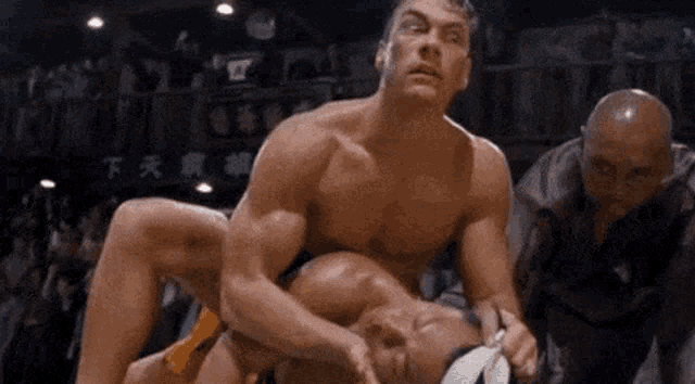a man is wrestling another man in a ring while a referee watches .