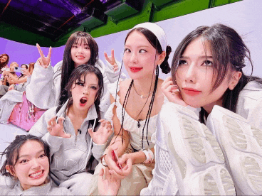 a group of women are posing for a picture and one of them is wearing a white shirt that says lg
