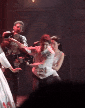 a man is holding a camera while a woman holds a man 's arm