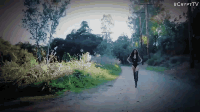 a woman in a black bodysuit is running down a dirt road with #crypttv written on the bottom right