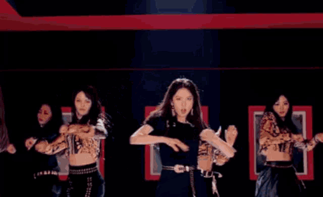 a woman in a suit and tie is dancing with other women .