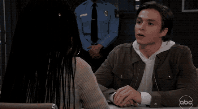 a man and a woman sitting at a table with abc written on the bottom