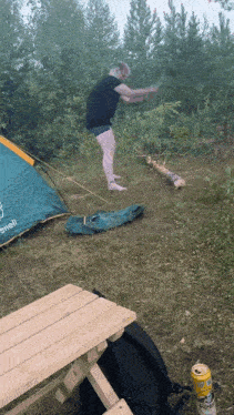 a can of pringles sits on a wooden table in front of a tent