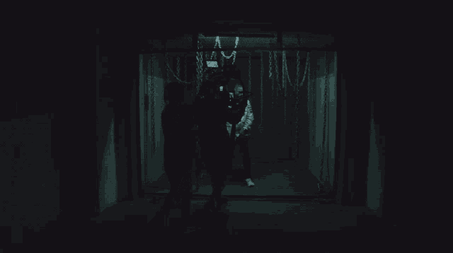 a group of people standing in a dark room with chains around them