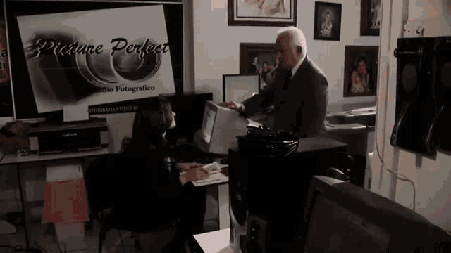 a woman sits at a desk in front of a picture perfect logo