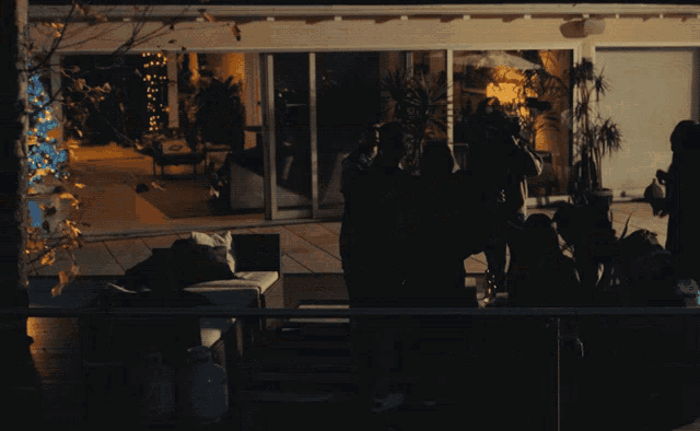 a group of people are gathered outside a house at night