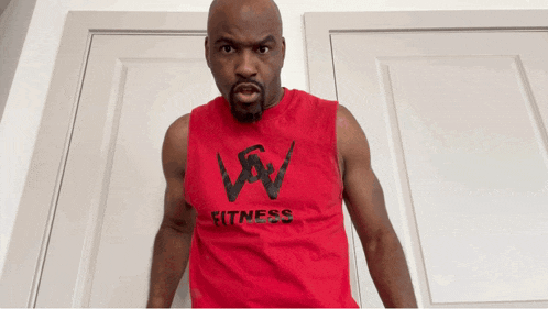 a man is wearing a red tank top with the word fitness on it