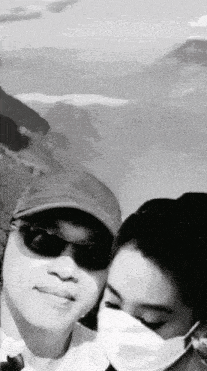 a black and white photo of a man and woman wearing face masks