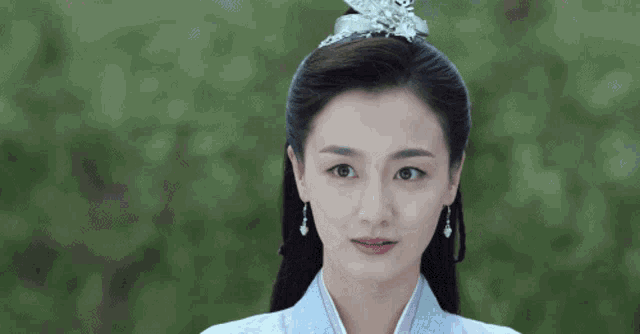 a woman is wearing a crown on her head and earrings