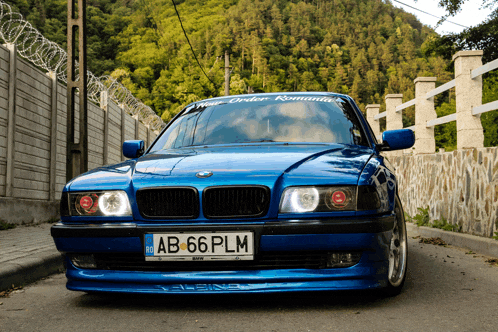 a blue bmw has a license plate that says ab 66 plm