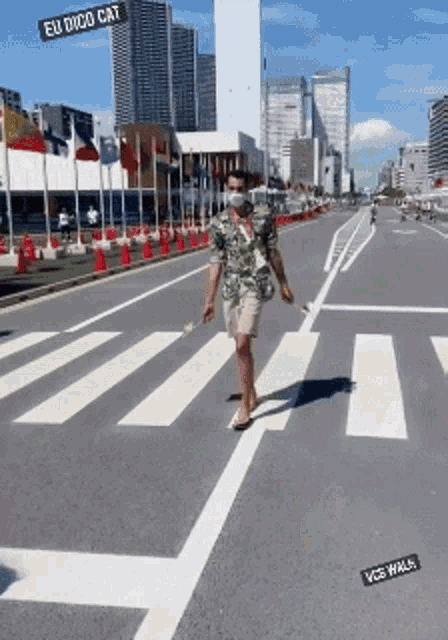 a man wearing a mask walks across a street with a sign that says eu dico cat