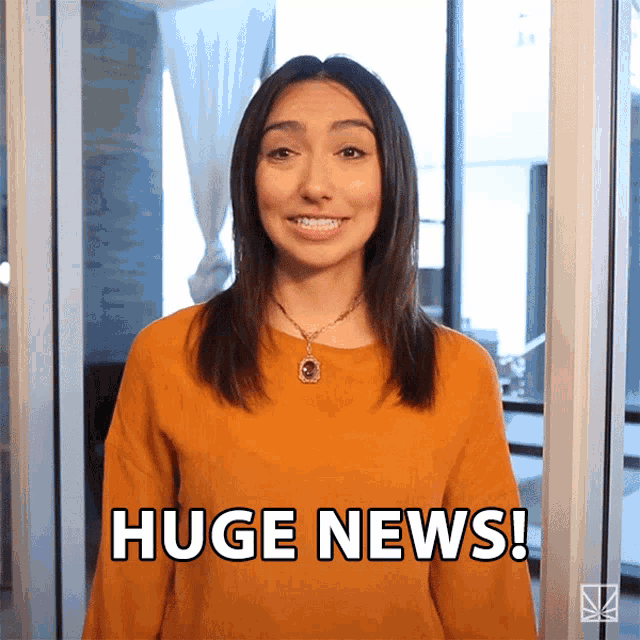 a woman says huge news in front of a window