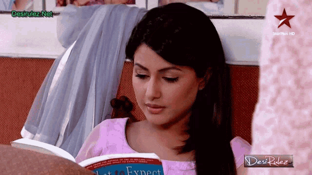a woman sitting on a couch reading a book that says expect