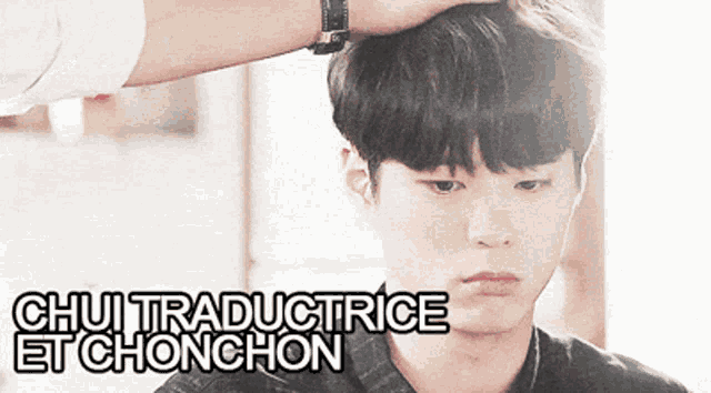 a man 's head is being touched by another man with the words " chui traductrice et chonchon " written above him