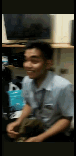 a blurry picture of a man in a blue shirt with a name tag on his chest