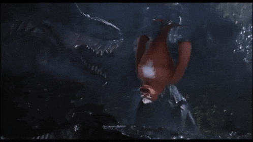 a man is being attacked by a large dinosaur