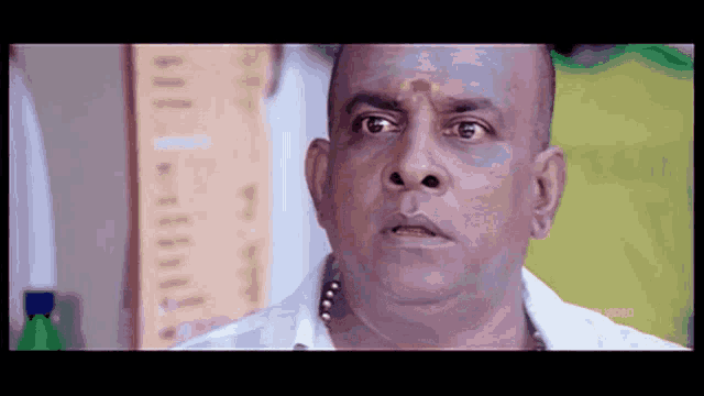 a bald man is making a funny face in a movie .