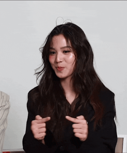 a woman with long hair is making a funny face with her hands
