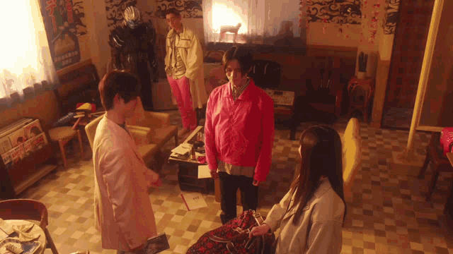 a man in a pink jacket is talking to a woman in a living room
