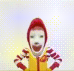 a close up of a mcdonald 's clown with his arms up in the air .