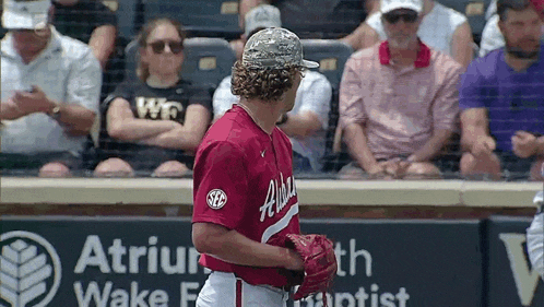 a baseball player wearing a red and white uniform with the word alabama on it