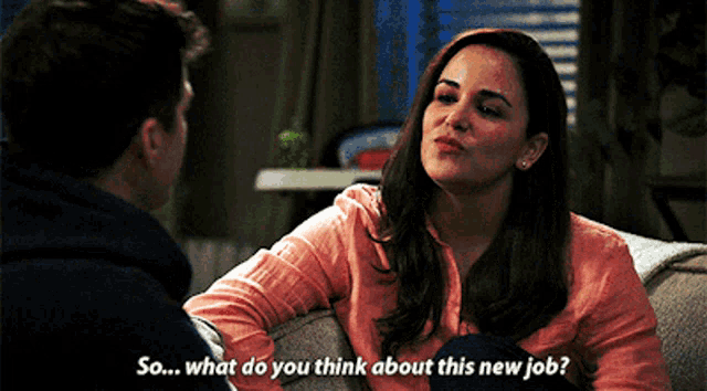 a woman is sitting on a couch talking to a man who is asking her what she thinks about her new job