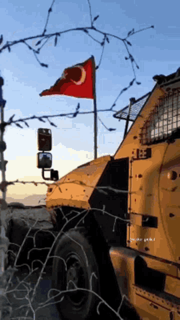 a military vehicle with a turkish flag flying in the background
