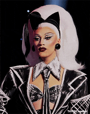 a woman wearing a black and white outfit with a bow on her head