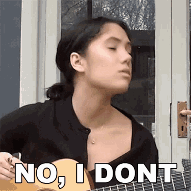 a woman is playing a guitar and says no , i dont .