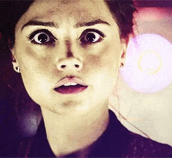a close up of a woman 's face with a shocked look on her face
