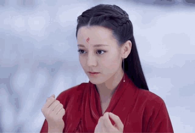a woman wearing a red kimono with a red flame on her forehead