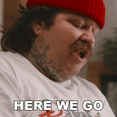 a man with a tattoo on his neck and a red hat says here we go