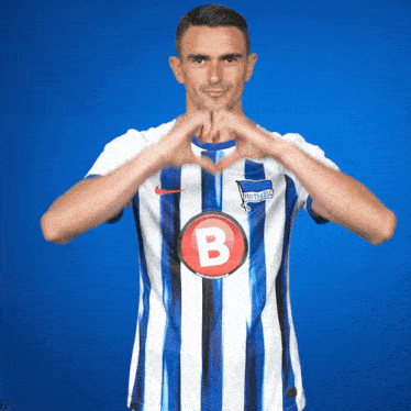 a man wearing a blue and white striped shirt with the letter b on the front