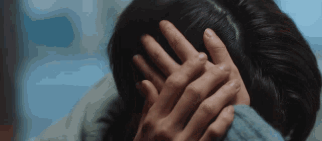 a woman is covering her face with her hands