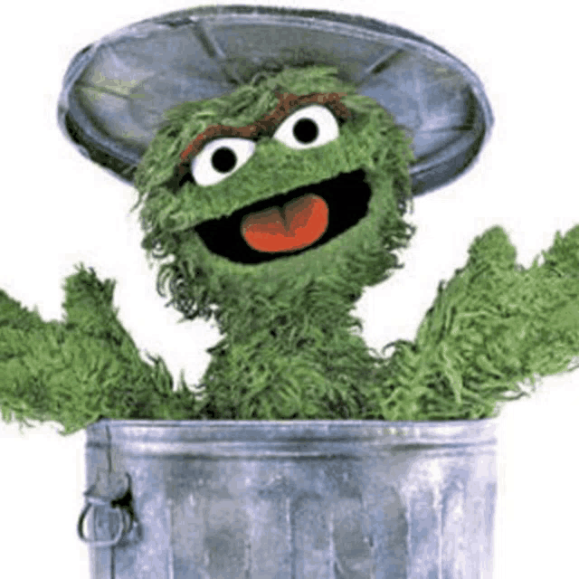 oscar the grouch is sticking his tongue out of a garbage can