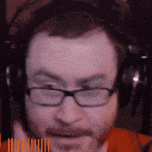 a man wearing glasses and headphones has a beard