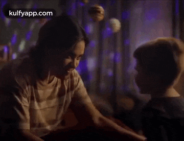 a woman and a boy are sitting next to each other in a dark room .