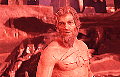 a shirtless man with a beard has a circle on his chest