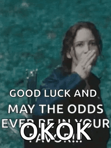 a woman is giving the middle finger with the words `` good luck and may the odds ever be in your favor '' behind her .