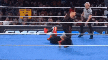 a wrestling match is going on in a ring with a referee and a sign that says solo rueda is this feud