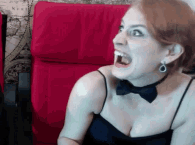 a woman wearing a bow tie and earrings screams