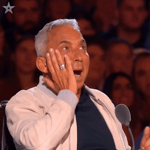 an older man with a ring on his finger looks surprised