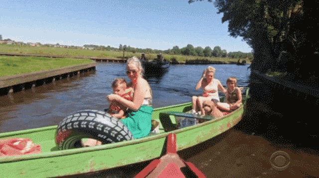 a group of people are sitting in a green boat