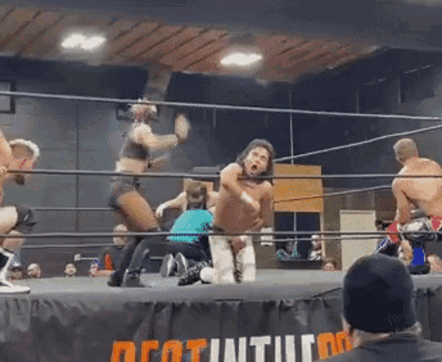 a wrestling match is going on in a ring with a sign that says decathlon