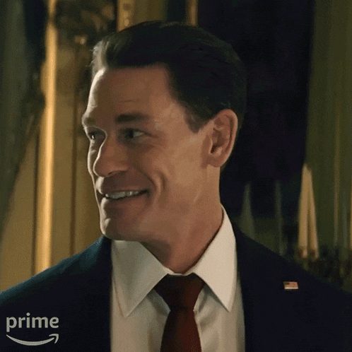 a man in a suit and tie is smiling in front of an amazon logo